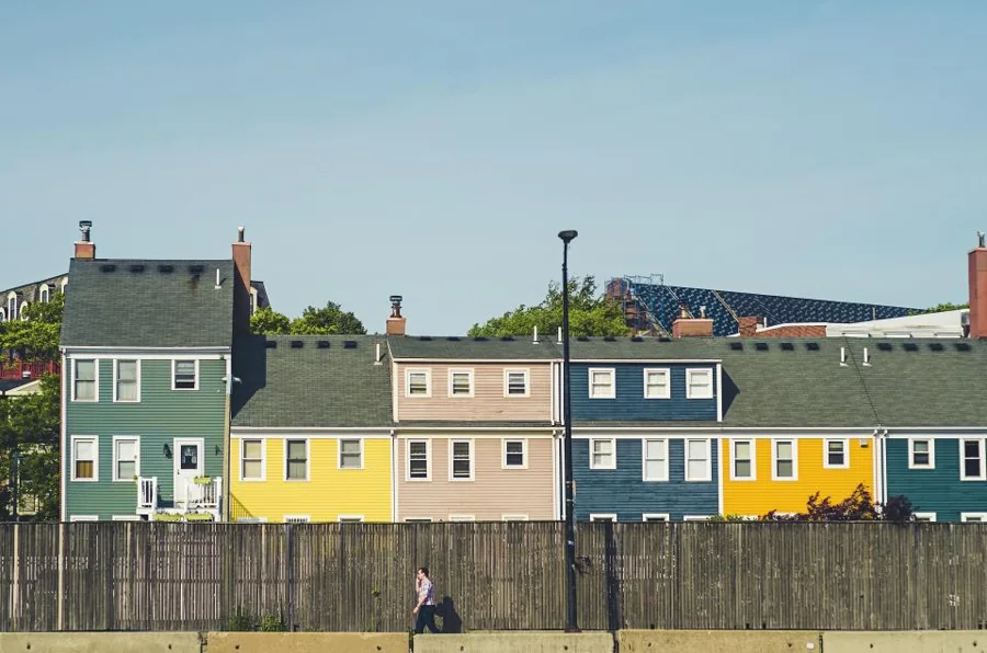 A row of colourful timber homes with pitched roofs